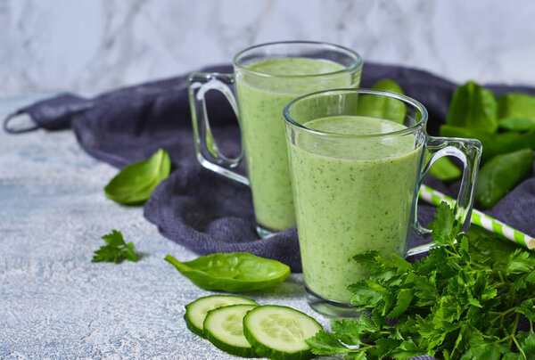 Green vegetable smoothie with avocado, cucumber and spinach.