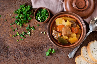 Stew with vegetables and potatoes on an old grunge background clipart