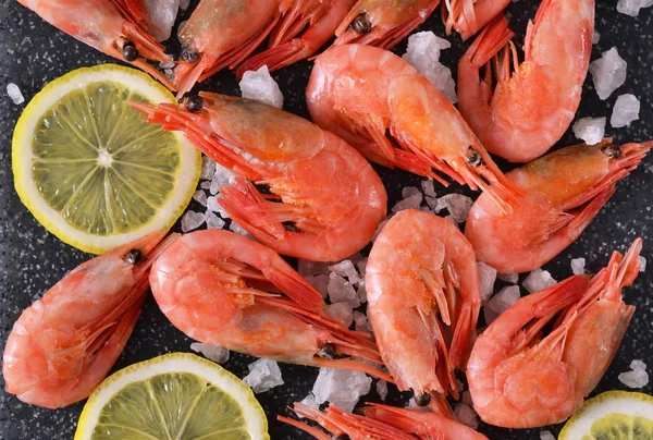 Camarones hervidos con sal y limón sobre un fondo negro de mármol — Foto de Stock