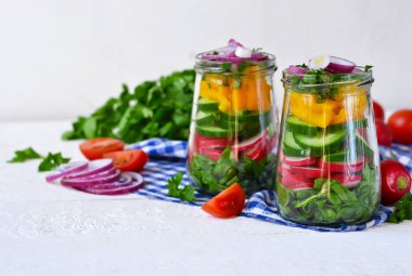 Ispanak ve cam kavanozda kırmızı soğan ile sebze salatası.