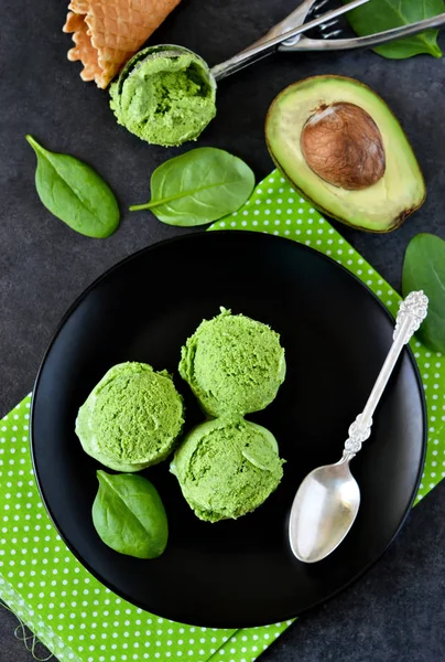 Ice cream with avocado, spinach on a black background.