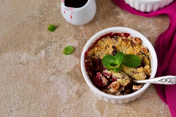 Crumble with berries, oatmeal and nuts on a concrete background — Stock Photo, Image