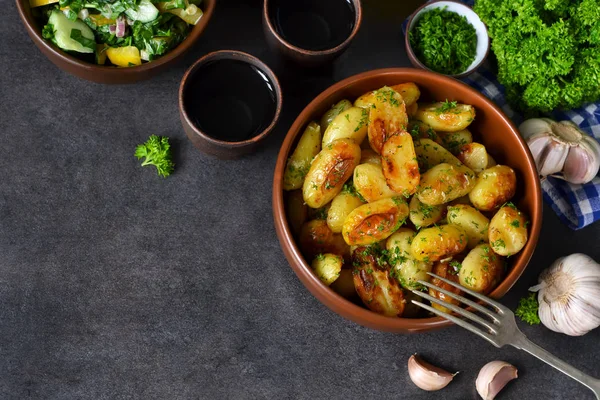 Junge Bratkartoffeln mit Knoblauch und Dill auf schwarzem Hintergrund — Stockfoto