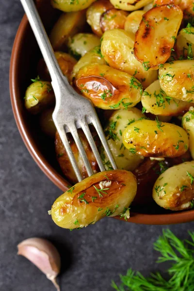 Young fried potatoes with garlic and dill on a black background — Stock Photo, Image