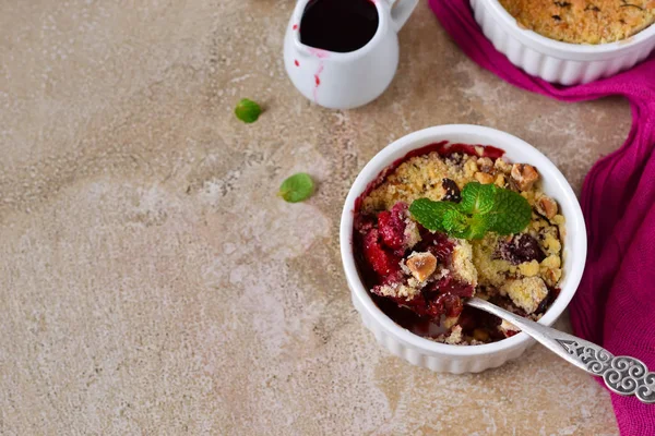 Crumble with berries, oatmeal and nuts on a concrete background — Stock Photo, Image