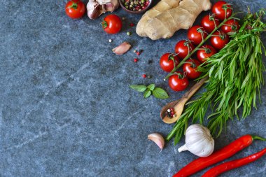 Gıda arka plan mermer bir zemin üzerine farklı malzemelerle. Kiraz domates, biberiye, sarımsak, biber, limon. Üstten Görünüm.