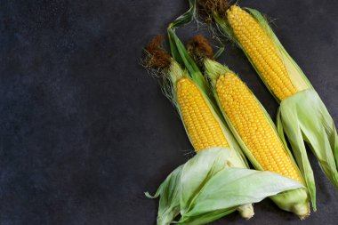 Siyah bir taş zemin üzerine taze, sulu, ham Mısır