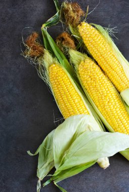 Siyah bir taş zemin üzerine taze, sulu, ham Mısır