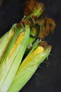 Siyah bir taş zemin üzerine taze, sulu, ham Mısır