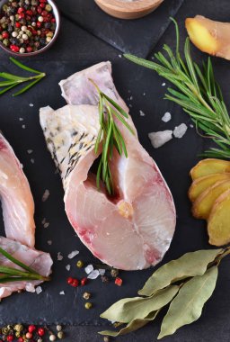 Biftek baharat siyah bir taş zemin üzerine beyaz balık.