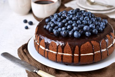 Ev yapımı çikolatalı kek krem ve beyaz bir arka plan üzerinde yaban mersini ile. Doğum günün kutlu olsun.