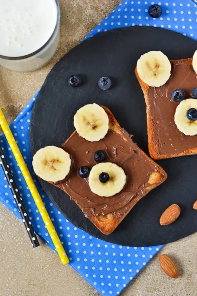 Sarapan untuk anak-anak - roti panggang dengan pasta coklat, pisang . — Stok Foto