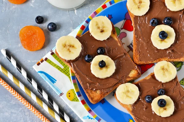 Breakfast for children - toast with chocolate paste, banana. — Stock Photo, Image