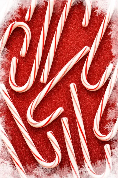 Candy cane on a red, shiny background. Winter new year backgroun — Stock Photo, Image