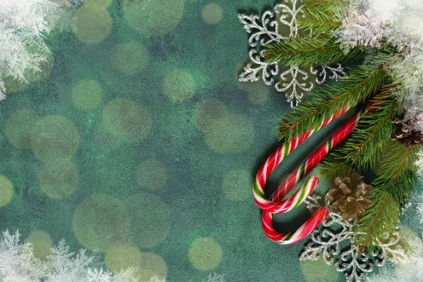 Χριστουγεννιάτικα πράσινο φόντο με γλυκά, νιφάδες χιονιού και κώνους. — Φωτογραφία Αρχείου