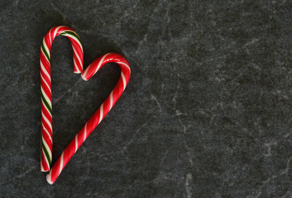 Candy Cane on a black marble background. Christmas background.