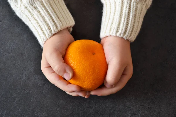 Çocuğun Mandarin elinde. Yeni yıl arka plan.