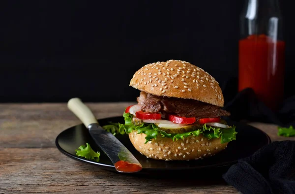 Hamburguesa casera con carne de res, ensalada y salsa de tomate . — Foto de Stock