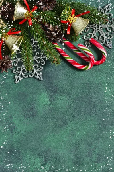 Új évet zöld háttér, édességek, hópelyhek és kúpok. — Stock Fotó