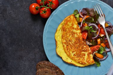 Kahvaltıda ekmek ve salata ile kırmızı omlet.