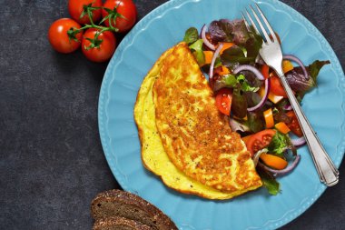 Kahvaltıda ekmek ve salata ile kırmızı omlet.