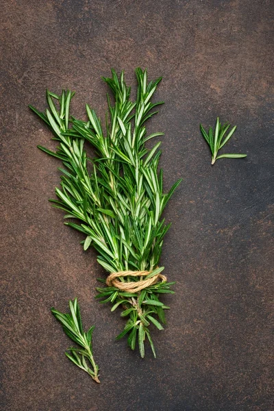 A fresh bunch of rosemary on a brown concrete background. — Stock Photo, Image
