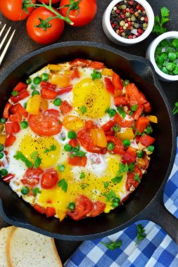 Domates, biber ve yeşil bezelye bir tavada yumurta.