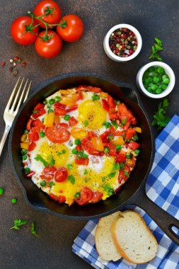 Domates, biber ve yeşil bezelye bir tavada yumurta.