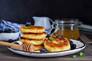 Klasik Rus kahvaltı - cheesecake bal ve çilek ile.