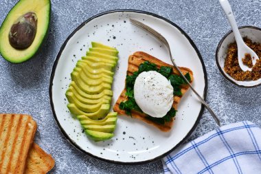 Hızlı kahvaltı - tost, ıspanak ve avokado ile haşlanmış yumurta.