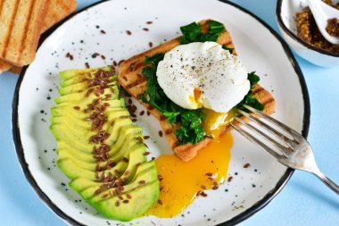 Hızlı kahvaltı - tost, ıspanak ve avokado ile haşlanmış yumurta.