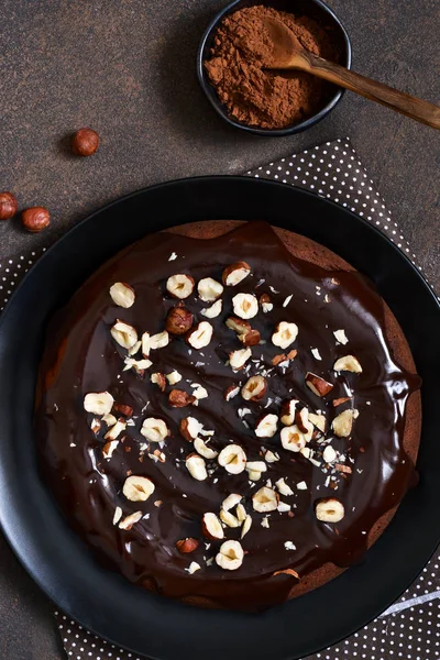 Pastel de chocolate con salsa de chocolate caliente y avellanas fritas — Foto de Stock