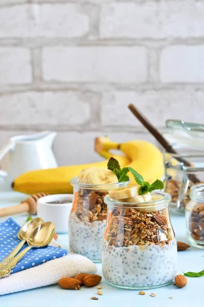 Йогурт з насінням чіа, гранолою та бананом на сніданок . — стокове фото