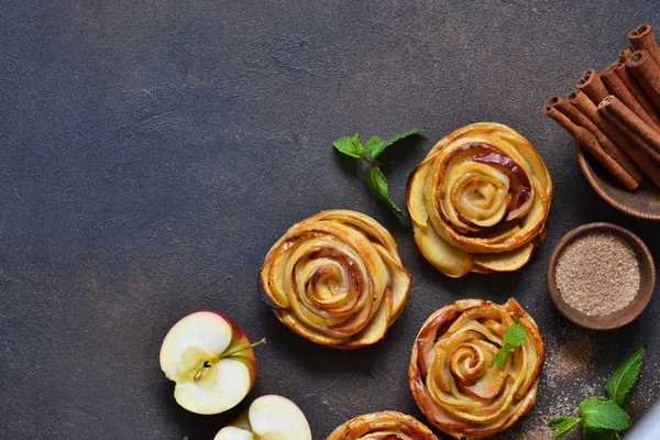 Блюдо яблочных роз, запеченных в слоеном тесте на темной бетонной спине — стоковое фото