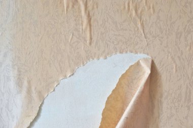 Duvardan eski duvar kağıtları kaldırılıyor