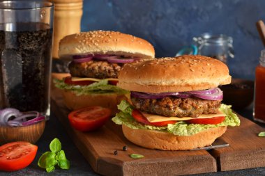 Beton torbaya sığır eti, peynir ve sos konulmuş ev yapımı hamburger.