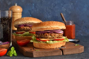 Beton torbaya sığır eti, peynir ve sos konulmuş ev yapımı hamburger.