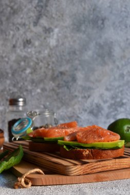 Avokado ve somonlu çavdar ekmekli sandviç. Yatay.