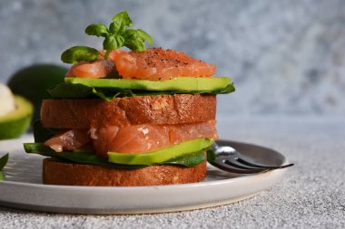 Avokado ve somonlu çavdar ekmekli sandviç. Yatay.