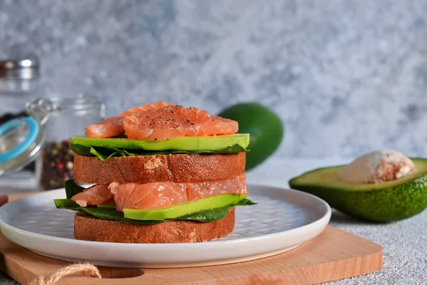 Rye bread sandwich with avocado and salmon. Horizontal.