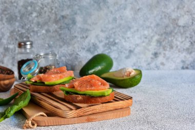 Avokado ve somonlu çavdar ekmekli sandviç. Yatay.