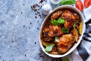 Fırında tavuk budu, patates, domates sosu ve fesleğen. 