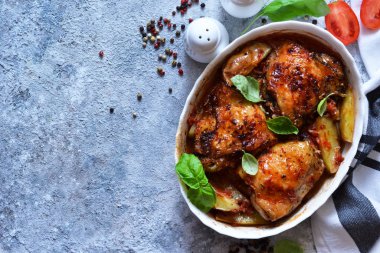 Fırında tavuk budu, patates, domates sosu ve fesleğen. 