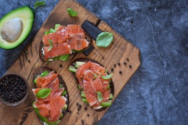 Beton zeminde avokado ve somonlu sandviç.. 