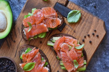 Beton zeminde avokado ve somonlu sandviç.. 