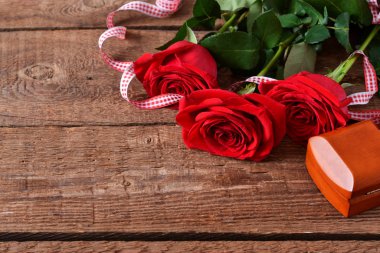 Ahşap arka planda kırmızı güller. Güzel kırmızı güller