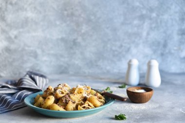 Beton zeminde soslu ve peynirli makarna..