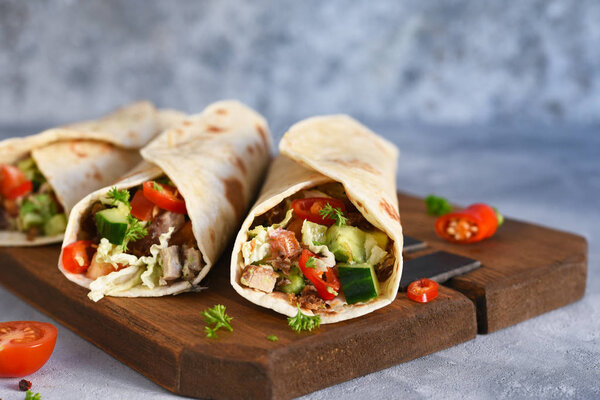 Burrito - mexican dish with corn tortilla, jasse, vegetables and