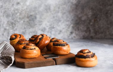 Beton zemin üzerinde haşhaş tohumu ve süt olan çörek.