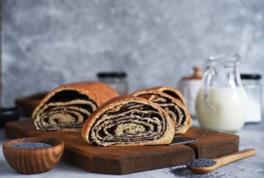 Beton zemin üzerinde haşhaş tohumu ve süt olan çörek.